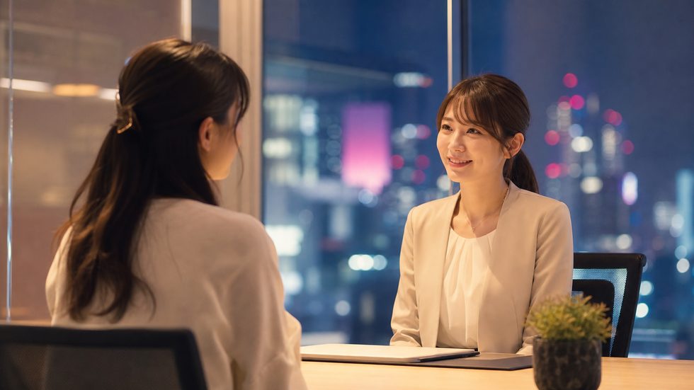 元チャットレディのスタッフと応募者が明るいオフィスで個別相談するシーン